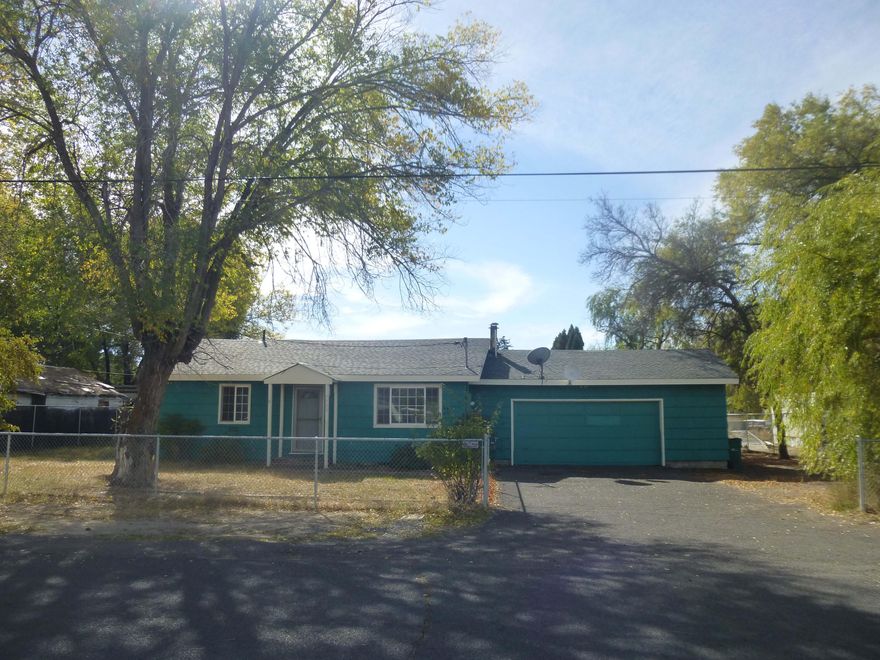 Why Pay Rent? First time Buyers or Investment Opportunity! This single story home is built  on large fully fenced level lot, pet friendly. This home features: 3 bedrooms, 1 full bathroom, oversize 2-car garage, covered patio,kitchen has newer gas range with hood, tile counter tops and dining area flows to nice size living room.  Easy care flooring tile, laminate and linoleum throughout. Ceiling fans in living room and primary bedroom. Well kept quiet neighborhood. Off street parking with possibility for RV parking. Close to bus line, schools & more. Easy to rent.