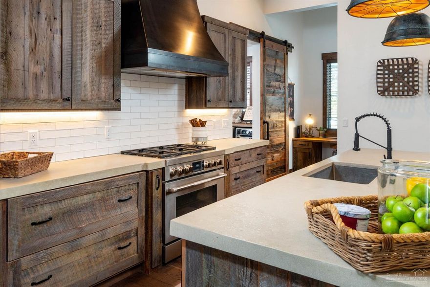 Rustic/Modern elegance in Caldera Springs! High end finishes throughout this custom home include gourmet kitchen with concrete counters, Jenn-Air professional grade stainless appliances and barn wood cabinets. Large butlers pantry with quartz counters, microwave, additional dishwasher, built in shelves and cabinets for lots of storage. Spacious mud/laundry room with built-ins lead to a 3 car garage. Wide planked hardwood floors and coffered wood ceilings throughout the open kitchen, dining and great room. 3 master suites downstairs with additional bonus/bunk room and full bath upstairs. Peek a boo Mt. Bachelor view from the bonus room. Large .41 acre lot with wonderful outdoor space that includes a private courtyard patio with fire pit and hot tub, along with an additional covered patio off butlers pantry and dining area.