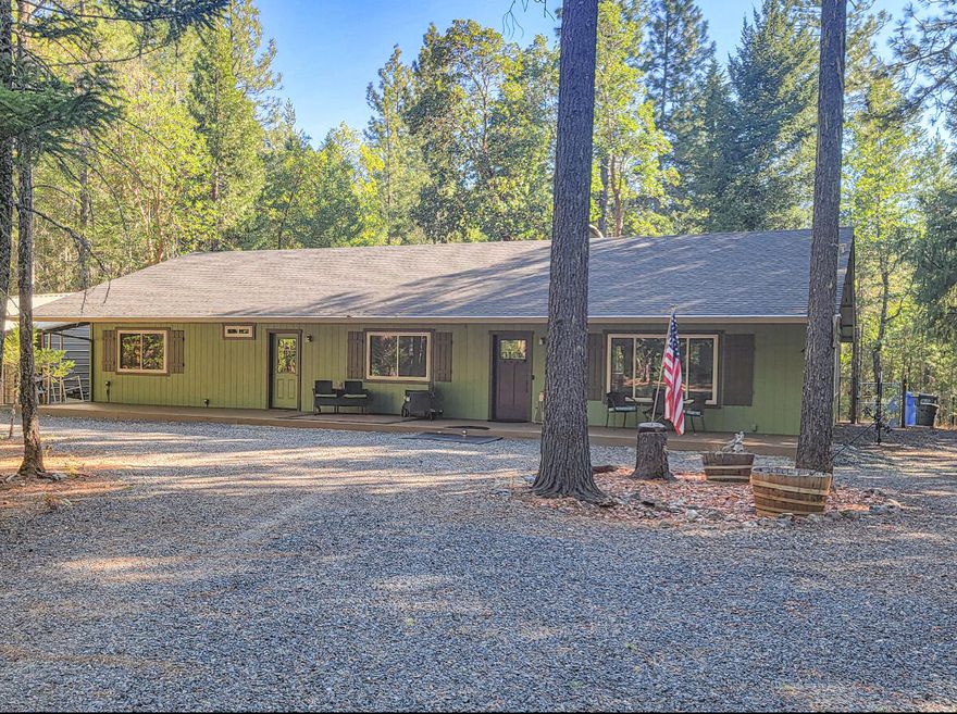 Country peace and privacy. This 1980 square foot home is comfortable, open floor plan, lots of light and windows to bring the outside in. The great room includes living, dining and kitchen area. Vaulted ceilings and ceiling fans add ambiance. There is a wood stove in addition to a new heat pump unit for climate comfort. Solar system keeps electric cost at a minimum. Very wooded 5 acres with walking paths and several outbuildings. 20x40 shop includes partitioned and insulated hobby room.  Large RV carport, another carport for parking, chicken coop, storage shed and 2 cargo containers for even more storage. This 3 bdrm 2 bath home is located at the end of a cul-de-sac with electric gate access and circular driveway. There is a covered deck the full length of the home and a hot tub out back. Kitchen has huge island/seating area with lots of storage. Includes all appliances you would expect (cooking = propane) and a trash compactor. There is a 50 amp RV service, water and dump.
