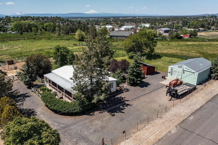Adorable updated 1976 manufactured home with country charm and modern touches! This well-maintained home and property features two bedrooms, large primary w/ on suite, large guestroom, great walk-in pantry, a small barn, a spacious shop, chicken coop, storage shed, and mature landscaping—all on just under an acre that gives it that peaceful, out-in-the-country feel. Whether you're looking for a hobby farm, workshop space, or just room to breathe, this property offers flexibility and function in a serene setting. Private financing available.