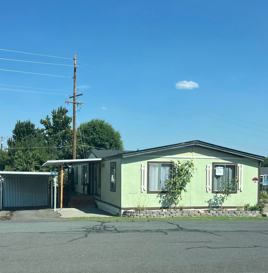 Partially updated three-bedroom, two bathroom manufactured home in a clean and quiet family-friendly park. This home sits on a nice sized lot and is in great condition for its age. The roof is about a year old and the laminate flooring is about 5 years old. This home has a great split floorplan with primary bedroom and en suite bathroom on one end and two bedrooms and a bathroom on the other end with the kitchen, dining, and living room (with a pellet stove) in the middle plus a large laundry area. This kitchen is spacious and has a newer convection oven and electric stovetop. The outside has some nice features...a mature fruit tree, berry bushes, a nice deck for entertainment and outdoor relaxation/enjoyment, a carport with a storage shed and a large shed with shelving in the backyard. This is in a cul-de-sac location with visitor parking directly across the street.