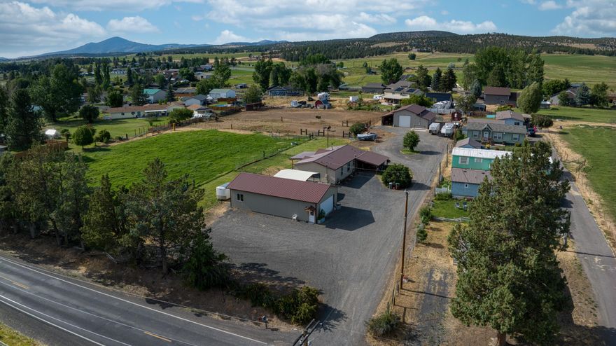 Superb NE location just outside town on a quiet country lane. Properties in this coveted area don't often come available. All the infrastructure and hard work has been done. The ideal set-up for animals with fenced & cross-fenced pastures and 2.4 acres of irrigation rights.  The barn is 48 x 48 with concrete floors, power, 3 stalls, tack room, plus there's a 12' overhang for hay storage or implements. A very nice 24 x 48 fully finished and heated shop with bathroom was added in 2022. The shop offers flexibility to use as a garage, workshop, crafts/hobby space and more. The circular driveway is a nice benefit for pulling a trailer and maneuvering large equipment. This property offers extra parking spaces on both sides of the shop and barn. Brand new LVP flooring was just installed and the interior of the home was freshly painted.