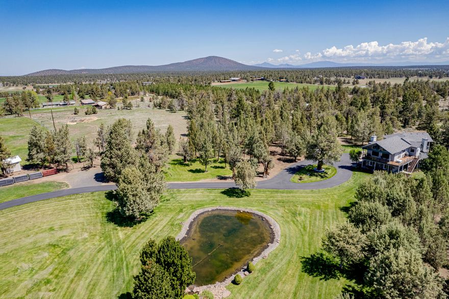 Located in the golden triangle of Tumalo, this pristine & peaceful property greets you w/ a custom entry gate, paved 700ft driveway leads past green pastures to a custom home w/ Cascade Mtn Views.  Ready for animals or car collectors w/ a 70x132 structure-or an indoor arena*,  barn area, 4 padded stalls, turnouts, heated wash area, tack room, guest quarters, outdoor dressing area, 8 loafing sheds, toy shed/hay storage, ~8000 linear ft no-climb fencing & X-fencing, 12 ac of Tumalo irrigation, fully automated, underground system, pond & dressage area.  Home boasts a chef's kitchen w/ Dacor gas range, SubZero fridge, granite counters & copper farm sink. Great room has wood vaulted ceiling, gas fireplace & west facing deck, 2 primary suites w/ deck & hot tub, 3 car garage, RV storage/hookups, Trexdecks & 67 solar panels, new roof in 2020!