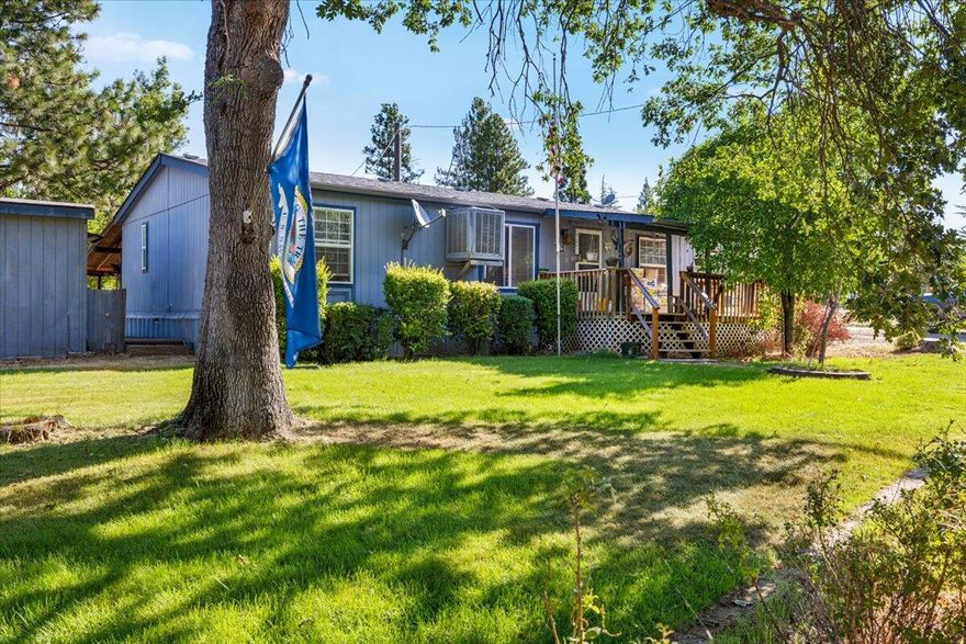 *Back on the Market at no fault to the property* Nestled on 5 peaceful acres, this charming 3-bedroom, 2 bathroom manufactured home offers the perfect blend of comfort and accessibility.  Inside you'll find an inviting split layout with a cozy living room, ample storage in the kitchen, newly updated primary bath with tile flooring and walk-in shower. Step outside to discover a peaceful yard with mature fruit trees and room for gardening, covered RV storage, a good-sized bonus space/workshop with a half bath and multiple sheds/outbuildings! Whether you're seeking a homestead, a great lot to build your dream home or a peaceful place to call home, this property delivers space, privacy and room to grow.