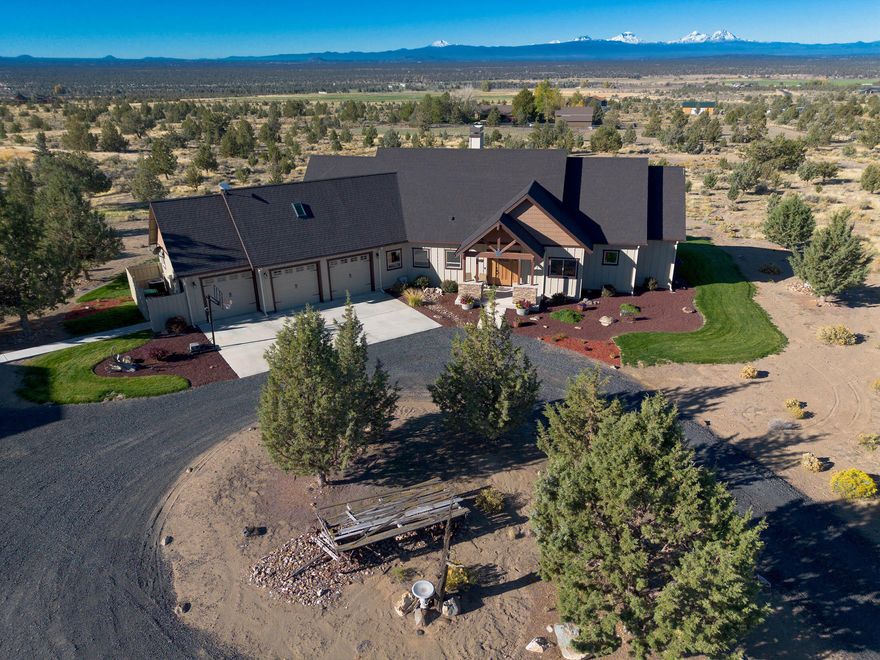 Minutes from Brasada Ranch, this custom-built home on 4.97 acres offers panoramic views of the Cascade mountains from Mt. Bachelor to Mt. Jefferson. This equestrian paradise includes an arena, round pen, and 1,728 sq ft barn with 2 stalls, tack room, and RV parking with power. The 3,224 sq ft home features stone pillars, oversized windows to capture those Cascade views, solid hardwood floors, and knotty alder cabinetry and built-ins. The kitchen impresses with granite counters, GE Monogram appliances, countertop and kickboard lighting, and walk-in pantry. The spacious primary suite on the main floor boasts cove ceiling lighting, soaker tub, and walk-through closet. The second floor offers 2 bedrooms, a full bathroom, and a home theater with new Bose Lifestyle 650 A/V system and automated blackout shades for elevated movie nights! The 3-car heated garage offers a workbench and additional storage. The private backyard is perfect for stargazing and entertaining with a built-in fire pit.