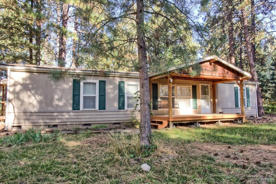 You don't want to miss this charming 1,554 sqft Deschutes River Woods manufactured home on .94 of an acre with 3 bedrooms, master separated from the other 2, 2 full baths, den, separate living room, dining area and family room off the kitchen. Incredible Lot! 280 feet along the Big Canal and it also has a small creek that runs through the property with a little bridge across it, you can pick wild raspberries on it. Front of home has hand carved large logs as a front covered porch which gives it the look of a house vs. manufactured home. This home has Has a huge deck that overlooks Pine trees, ducks, canal, with the most lovey setting ever. Lots of parking with the detached shop/garage with lots of possibilities, plus RV parking! Covered wood log shed to hold your cut wood , plus approx. 14 X 13 wood storage shed. Enjoy being at the end of a cul-de-sac on a great street! $2K appliance allowance at closing with an acceptable offer.