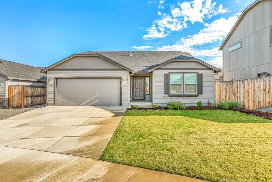 This 2019 built home sits in the Delta Estates Subdivision in East Medford. The 1408 square foot Edgewood model is an efficiently-designed single level home offering both space and comfort.  This beautiful 3 Bedroom 2 bath boasts an open floorplan and upgraded trim package. Upon entering the home you have an nice wide hallway, 2 bedrooms and a full bathroom on one side and the primary bedroom and ensuite bath on the other with ceiling fan, 2 walk-in closets, dual vanity, enclosed water closet, and walk-in shower.  The kitchen features a breakfast bar overlooking the vaulted ceiling living room with ceiling fan, dining area, granite countertops, large pantry, glass top range/oven, and ample cabinet space.  Garage has a man door leading to the side yard and two 4' X 8' SafeRacks mounted to the ceiling for a ton of extra storage.  Outside you'll find a covered patio with a natural gas outlet for BBQ together with a nice sized, fully fenced, back yard for your family gatherings.