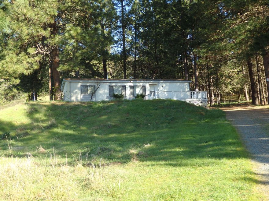Country living on 5+ view acres. Enjoy mountain and valley vistas on this rolling acreage. The 1991 Guerdon double-wide manufactured home is livable but in need of work. The split bedroom floor plan emphasizes personal privacy. Spacious vaulted living/dining area with built-ins and pass through to the kitchen. Pantry. Pellet stove for cozy winter evenings. Small shed and lean-to for extra storage. Plenty of room for RV/toys. With the homesite at the rear of the property, the setting is remarkably private. Please note the back deck is not usable. This is an ''as is'' sale only.