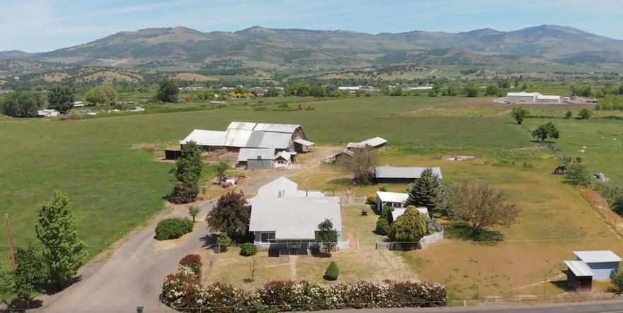 Water-rich EFU 49 acres with 1602 sqft, 4 bedroom/3 bathroom, 1930's farm house, huge pole barn, 6 outbuildings, very close to Talent! Beautiful acres of alfalfa, fescue, & clover grown on Class 2 soil. Owner has never used pesticides in the past 30 years. Plenty of water - 45 acres of TID water rights, Anderson Creek flows across the property, and there's a pond. The farm house has fir wood floors, large kitchen, laundry room, and a bonus bedroom with full bath and area an for kitchenette. There's a well, a well house and a cement holding tank built in 1994. The 2nd original farm well has been used for irrigating around the house. Huge pole barn is 5076 sqft and has 14 stalls! Property has a horse corral, 6 other outbuildings, 3-stall carport and is fenced and cross-fenced. If you're looking for a potential organic farm, or business agriculture such as HEMP, then this is the perfect place! One-of-a-kind rural farm land in the heart of Talent with land, water, and a home!