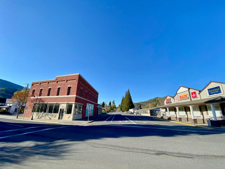 Incredible income potential in this historic icon in the heart of downtown Rogue River. Two beautifully renovated upstairs flats with 12' ceilings, large windows, and views of downtown. Ideal for rentals or to live in while you run your business down stairs and collect income from other tenants in the Old City Market building. The 2 upstairs completely remodeled residential flats are 1500+/- s/f each with new tile, cabinets, washer/dryer, windows, & AC. The main level is 3325+/- s/f retail business offices with unfinished red brick basement of 1280 s/f. with new mini split and dehumidifier ideal for wine tasting room or events. The building has been renovated with new red cherry flooring, heating system, new roof & more. 9 on-site parking spaces as well as street frontage. Furnishings included with apartments which were bringing in $300 per night as short term rentals or $1500 as long term! Interior photos coming soon.