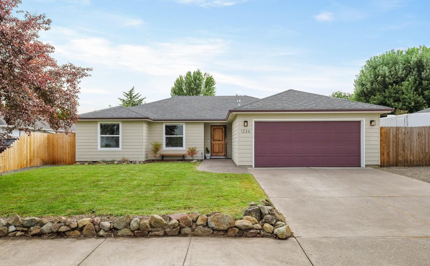 Set on a quiet street in Central Point, this single-level 3-bed, 2-bath home blends comfort & convenience with recent updates that create a fresh, move-in-ready feel. Step inside to a welcoming living room where vaulted ceilings & large windows frame the backyard & flood the space with natural light. The open layout flows seamlessly into the dining area & kitchen, offering abundant counter space, bar seating, & room to gather. A separate utility room keeps laundry tucked away, while the hallway provides additional built-in cabinetry for storage. Bedrooms are well-sized, with the primary suite featuring a walk-in closet & an ensuite bath with a double vanity. Outdoors, enjoy a resurfaced in-ground pool, hot tub, covered patio, & seating area, perfect for summer barbecues, winter soaks, or evenings under the stars. The low-maintenance yard, detached shed, & RV parking add flexibility for hobbies, projects, and storage. Seller is related to listing agent