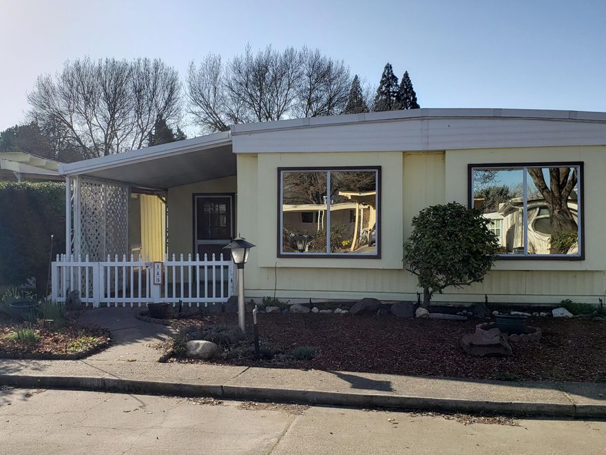 This home is move-in ready and features an open floor plan with 2 bedrooms and 2 bathrooms. Master suite features a walk-in closet with plenty of storage. Both bathrooms feature walk-in showers for easy access. Additional bedroom with large closet for guests or a hobby room. Newly remodeled sunroom with separate walk-in pantry/storage. All appliances included (washer & dryer are near new). HVAC system replaced in 2021. Outside features large covered parking and breezeway, yard is fenced and gated, outside shop for hobbies, and easy maintenance grounds with mature plantings. Home is located on a quiet corner lot in the 55+ Aspens on the Creek park. The park features laundry room, car cleaning station and a dog wash station. The large club house/community center is newly remodeled with a full kitchen & game room which can be reserved for family events. They pride themselves in providing events and activities for all to enjoy such as movies and popcorn, potlucks, group games & activities