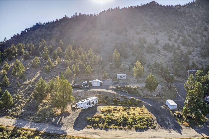 Sprawling over 2.54 acres, this beautifully improved lot in the Juniper Hills subdivision is ready for your dream home or manufactured home. The previous home was recently removed, giving you the option to build on the original homesite or take advantage of the higher ground for even better views. With all utilities still in place, including power, septic, and community water, you can skip the hassle of installing major infrastructure. This property is on the community water system, so there's no need to worry about maintaining a private well. Even more improvements have been made, including new 1 inch PEX water lines, multiple frost free hose bibs, and two RV hookups - ideal for guest or for temporary living while you build. A garage and storage building are already on site, offering a convenient space to store tools, outdoor gear, etc.