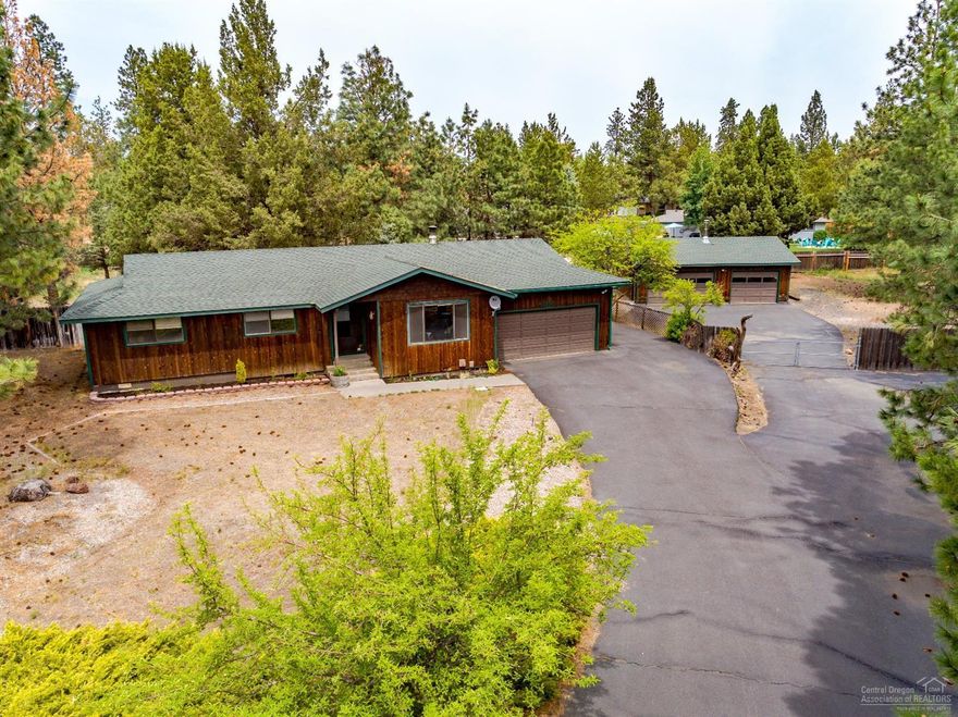 You will love this charming single level home situated in Kings Forest on Bend's East Side. The home offers 3 Bedrooms, 2 bathrooms, a spacious living area with wood pellet stove, laminate wood flooring, new tile flooring in the kitchen and dining room and solid stone counter tops. On the .72 acre lot there is plenty of space for parking trailers, boats, RVs and NO HOA! The attached 2 car garage is oversized (22'deep x 19'6 wide) and there is a 3 car detached garage (24'deep x 32'wide) with shop space!