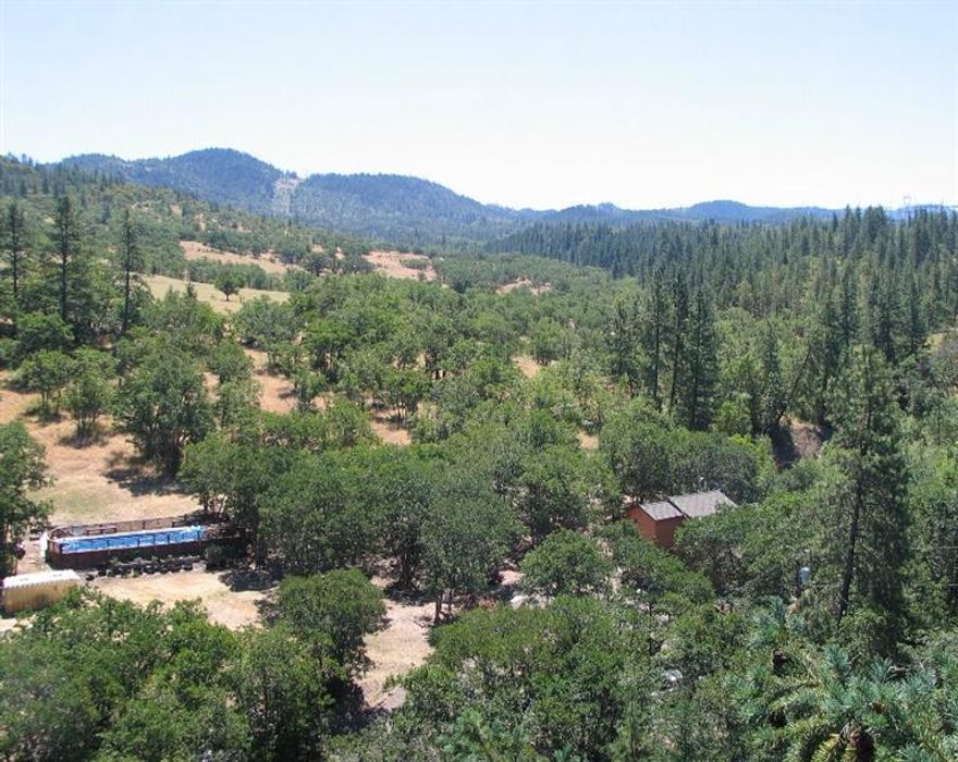 A little piece of Oregon in a VERY private, peaceful setting with fertile areas of pasture perfect for an orchard, organic garden. Newer engineered bridge across seasonal Dry Creek and solar powered auto gate at front entrance to property. Custom home with large, vaulted, wood & beam ceilings, tile entry with open railing staircase. Island kitchen with tile floors, electric cooktop, refrigerator, wall oven & microwave that opens to great room with vaulted ceilings and 2 sliding glass doors that open to the redwood deck offering magnificent views to the seasonal creek, wildlife and mature trees. 2 large bedrooms with vaulted ceilings and attached tiled bathrooms, as well as a large 3rd bedroom upstairs. Inside washer/dryer hookups. Newer septic tank & system, roof, and well pump.