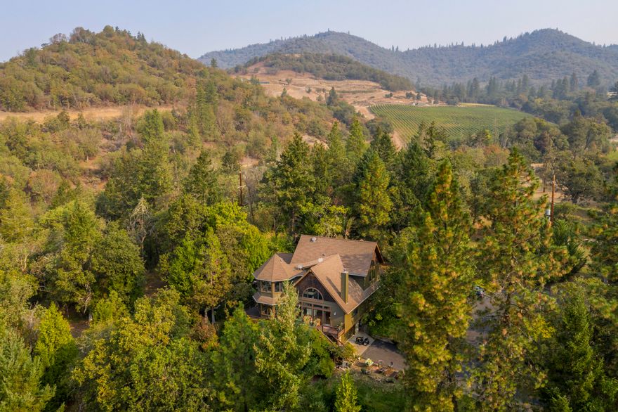 Secluded 15 acre Applegate wine country property with gated and paved driveway leading to a custom home with endless features. Starting with a carved mahogany front door, custom passive solar south facing property, 20 ft ceilings in the great room next to a designer kitchen, with a 135 inch long granite island. Arched entries make their designer statement, and every room features Gienow wood windows and doors framed by dark recycled wood that look out to incredible views.4 Bdrms 3 bathrooms with marble/slate floors and antique English vanities. Oak floors flow throughout the main living area. 2 carved wood gas fireplaces are stunning features plus a wood stove surrounded by stones. Upstairs are two private bedrooms, office, and library, you see expansive views from every window in this dream home.  24 gallon well 2 heat pumps 2400 square-foot shop that contains a private guest quarters. The property features mature gardens, meadows and forest with 2 seasonal creeks