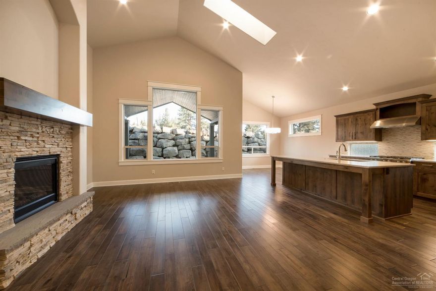 Lovely single level home from Pahlisch Homes features a grand entryway with archway, coffered ceiling & wood floors. Step into the dramatic vaulted great room with stone fireplace, skylights & large windows. You'll love the roomy kitchen with quartz counters, 5-burner range, stainless steel appliances. Master suite w/tile shower,tub & huge walk-in closet. Plus a 3-car garage! Amazing community amenities, resort-style living in Bend! Photos of similar home, specs will vary. PINEHURST-3-C-2215-1