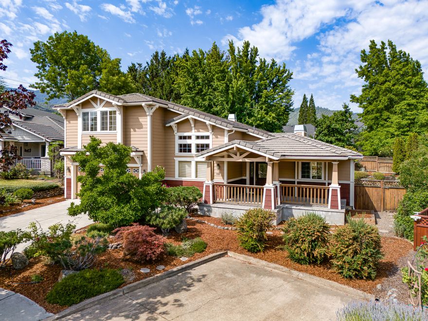 Discover the essence of tranquility in this exquisite home, where every detail enhances your daily life. Begin your day with a cup of coffee on the expansive covered front porch, overlooking lush gardens and mountain views. Step inside onto stylish tile floors that lead you to a den or formal dining room boasting soaring ceilings and large windows framing the natural beauty outside. To the right, a chef's dream kitchen awaits, complete with a generous island, granite countertops, and ample space for culinary creations. This kitchen seamlessly flows into an open living room and second dining area, perfect for gatherings. From here, step out to the covered back patio, ideal for summer barbecues, surrounded by meticulously landscaped gardens in the fenced backyard that adjoins open space. The main level also features an oversized half bath and a convenient laundry facility. Finally, retreat to the spacious and luminous master suite, where a corner gas fireplace adds warmth and charm.