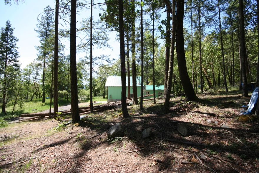 Forest Setting and Usable Land! This is a very nice 9+ acre parcel offering a peaceful country setting. 380 sq.ft., 2 story shop/garage with 200 amp electric and living space to enjoy while you build. Located on a well maintained road in an area of good producing wells. Well maintained forestland with a small pasture area and gated entry. Humbug Creek frontage across the country road is accessible by deer trails but could easily be cleared for easier access and a quaint recreation spot. Located amongst nice homes and 10 minutes to the Applegate River and conveniences.