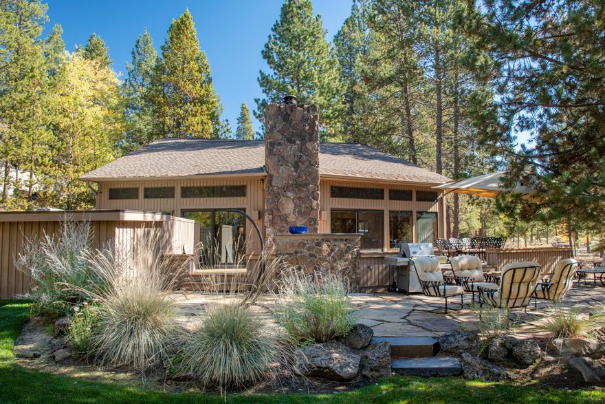 Located on an exceptional lot, with tons of rustic charm and elegant touches throughout, this contemporary cabin is the perfect spot to enjoy Sunriver. Expansive outdoor living space overlooking large common area, with wrap around deck, flagstone patio, private hot tub and large eating area. Inside you'll find a vaulted, crescent-shaped great room w/ cedar walls and ceilings, tons of windows and a lava rock fireplace, all creating a classic cabin feel - but with updates throughout including the furnace & AC in 2024.  Kitchen updates include newer cabinets, stainless appliances, slab granite countertops w/ tile backsplash. Bathrooms have been updated w/ tile floors, counters, & showers. Upstairs, two bedrooms share a generous loft, overlooking the great room. Sold fully furnished. The amphitheater is out back, SHARC is down the street, and The Village only blocks away...all within close proximity. This is a wonderful home for everyone to gather, indoors or out!