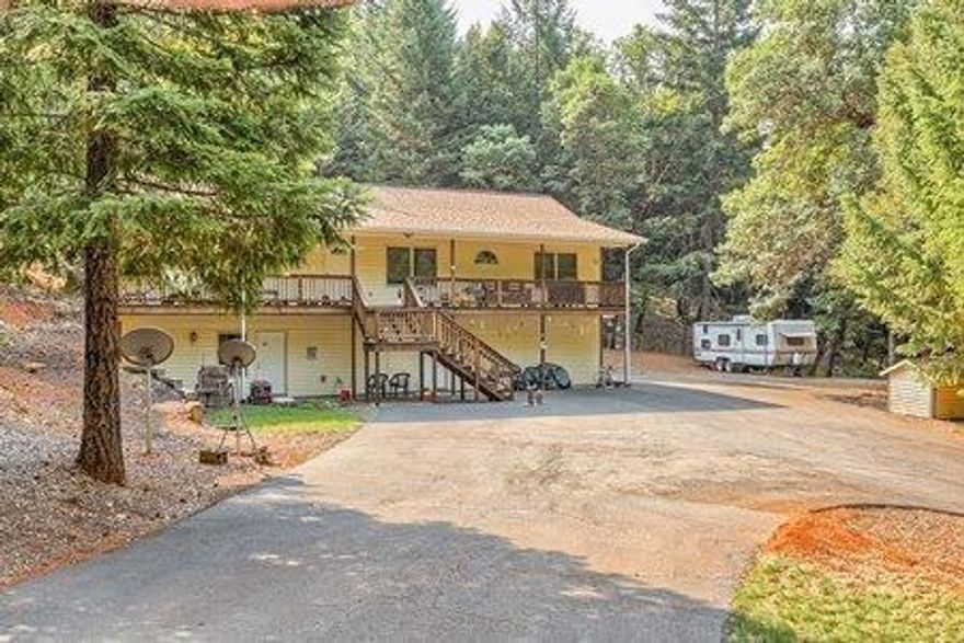 Serene wooded setting on 5.23 acres! Vaulted floor plan with wood beam ceiling accents & hardwood floors. Attractive stacked stone fireplace with pellet stove insert, decorator/plant shelf & corner built-in shelving in living room. Kitchen has oak cabinetry, gas (propane) cooktop, wall oven, dishwasher, microwave, refrigerator & large walk-in pantry. Master suite offers walk-in closet, double sink vanity, jetted tub & separate shower. Finished basement has tiled bonus room & bathroom plus a separate entrance door from the outside. Large laundry room - washer & dryer included. Central house fan. Decks in front & back. RV parking with hook-ups. Finished, oversized 2 car garage. Large block storage building. Fenced garden area. Paved driveway. Fire suppression work completed. Property borders BLM land. Peace, quiet & fresh air!