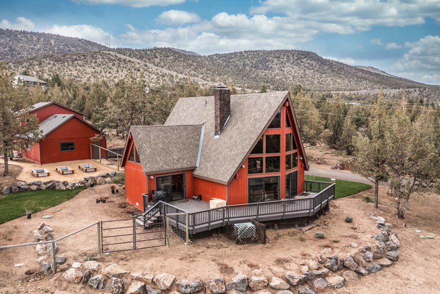 This beautiful 3 bedroom, 2 bathroom chalet style home has everything you're looking for including a 1 bedroom, 1 bathroom Guest House. Experience the peace and privacy of this home while enjoying the Cascade Mountain and Smith Rock views from your deck or while inside the home. The two story great room is incredibly warm and inviting with its wood burning stove, wall of windows providing extensive natural light and natural wood flooring. The master bedroom, loft, living room and dining area all feature a knotty pine tongue and groove ceilings which adds to the modern rustic feel. The loft offers so many possibilities; office, study, reading nook, play room, etc. Just off of the main home you will find a 2 car garage which is attached to the beautiful Guest House. In the large fenced yard you will find a playset, raised garden beds and beautiful grass lawn. The 5 acre lot allows for plenty of room to park all of your outdoor toys including RV's, boats, ATV's.