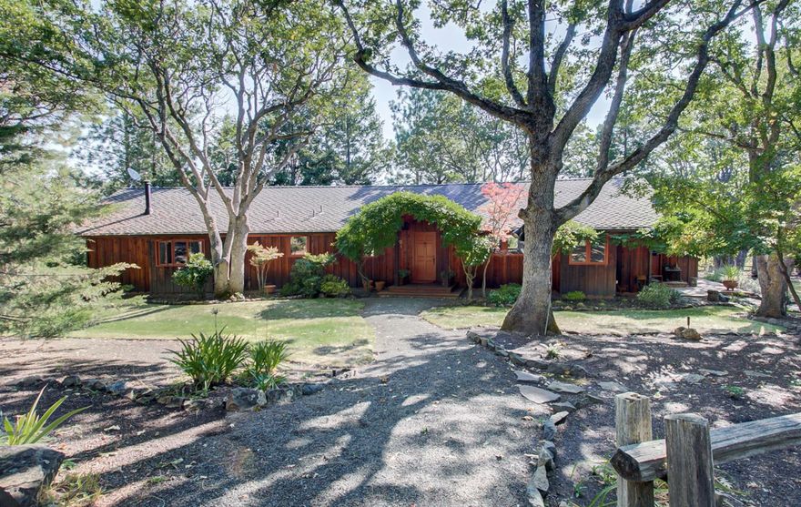 An amazing country home. The original owners are now selling their dream home. One story home with views of Emigrant Lake and the mountains or you can enjoy your own pond which has bass and bluegill & its own island, a small boat included! This home features cedar exterior and redwood interior walls and high vaulted wooden ceiling with large beams. Open floor plan with a generously sized living room, opens to the kitchen, dining area and a very large viewing deck. The bedroom wing has 3 bdrms or 2 & an office/hobby room. Master bath and the 2nd bath both have walk-in showers and lovely tile/stone walls or floors. Master bedroom has a high ceiling, tons of built-ins, direct access to the deck with views, and Bay window. Spectacular fenced-in garden area with pathways, a new green house or possibly 2, a large old barn with shop, extra storage areas & easy drive thru entrance/exit. 2 tax lots each with TID. A very rare find with views and just minutes to shopping or recreational areas