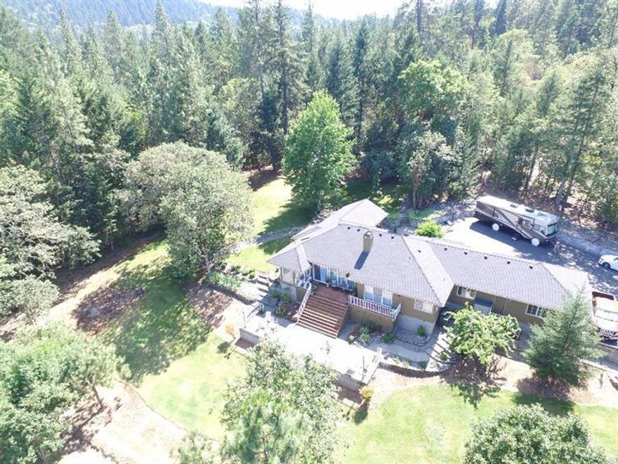 Magnificent is one word that describes this country beauty west of Grants Pass off of Riverbanks rd. Gated entry to your paved driveway where extra parking is and RV parking. There is extra parking on the west side of the property as well. Shaded areas with Green pastures will be the backdrop for any guests. New paint, roof, kitchen and other great touches makes this home go the extra mile. Your front patio has its own Covered area with gas fireplace which is perfect for those any time of day relaxation. For bigger gatherings come to the backyard to play sports, enjoy the large deck overlooking the mountains and valley or put up a hammock and relax. The Oregon life greets you here from every angle and the extra touches in the house and outside just makes this feel like home. Dare to compare this one to others and see for yourself. The pictures and video only tells one story.the true story is seeing it in person. Fully fenced with many extras, don't let this Oregon Beauty slip by