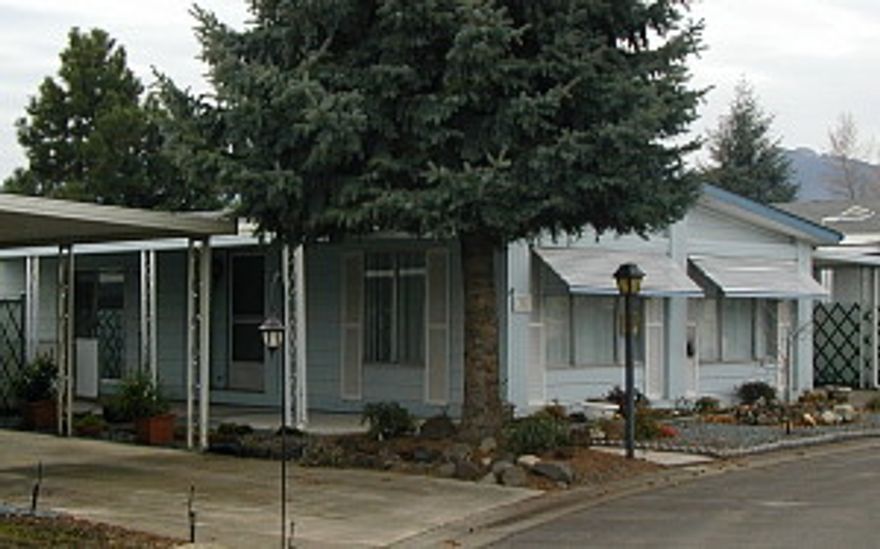 55+ Park. Like new inside, spacious double-wide has newer furnace, carpeting, vinyl, kitchen range, dishwasher, paint, tape & textured walls. Yard partially fenced for small pet. Sliding glass doors to side patio and back deck overlooking Bear Lake. Walk-in showers/both bathrooms. Priced to sell, ready to occupy. Park features: pool, sauna, weight room, shuffle board and club house.