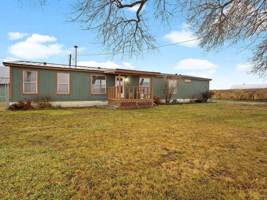 Charming countryside 3-bedroom, 2-bath home on 6 irrigated acres with KID Water District rights, conveniently located close to town. The property is fully fenced and cross-fenced, ideal for animals or hobby farming. Features include a metal roof, Blaze King wood stove, low property taxes, and a shed for additional storage. Inside, enjoy a spacious living room, generously sized bedrooms, and a private primary bathroom. A perfect blend of rural living with nearby amenities.