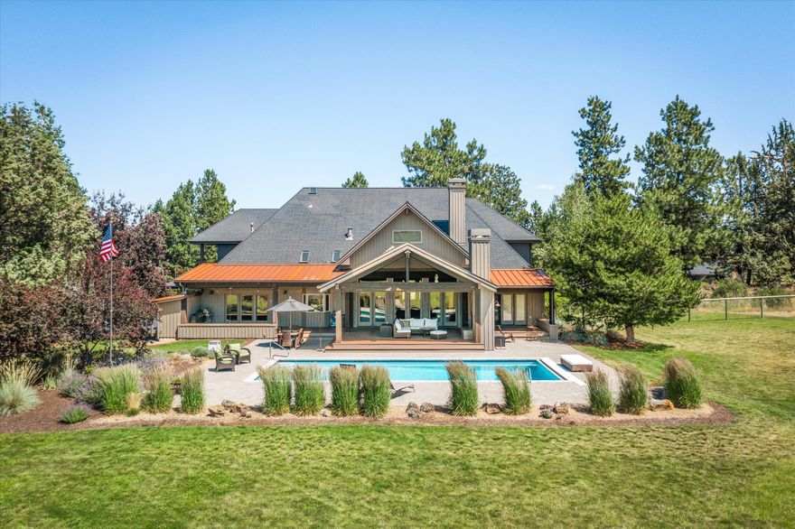 This estate-like 5 acre property offers a life-style which is rare to find in close-in beautiful Bend.  The long, private and gated driveway welcomes you to a fully fenced private enclave that boasts Cascade mountain views overlooking an incredible swimming pool and manicured pastoral lawn with easy irrigation. The gentleman's ranch set up with two-stall barn allows for horses and will entice the greatest of outdoor hobbyist looking to enjoy or expand into activities as gardening in the greenhouse or bee-keeping.  The covered outdoor walk-out patio graced with an outdoor fireplace is an oasis for both relaxing and entertaining poolside. The floor plan of this home mirrors the elegance of the property it sits on with open flowing kitchen and living spaces, primary on the main level, spacious bedrooms, wet bar, and a large studio-like exercise room with private bathroom.  The 4-car garage is heated and has a shower and additional storage.  This discerning property is truly one of a kind.