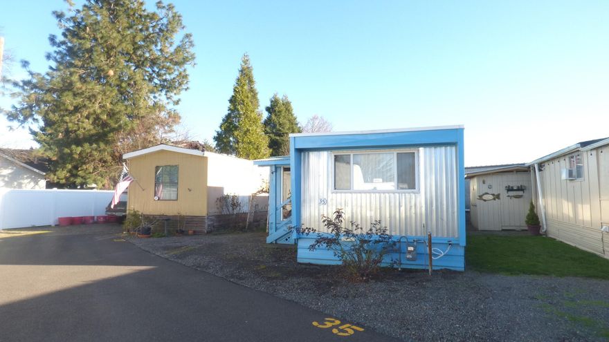 This manufactured home is located on a lot tucked into the back of the 55 + Valley Center Park in North
Medford.	This 764 sqft home features 2bed/l bath, double pane vinyl windows and some aluminum. Newer roof replaced in
2018 and a newer water heater.	The refrigerator, gas range/oven and stackable washer/dryer are
included.	The large covered deck to the side of the house offers a nice living space addition.	Also,
included are planter boxes to garden.	the space rents includes water, sewer and trash. SOLD AS IS.