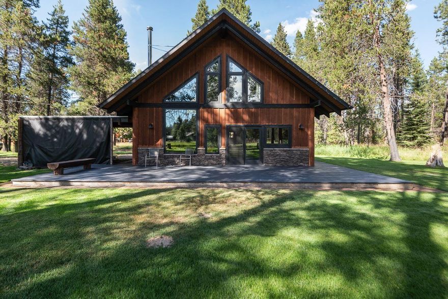 A river flows alongside this unique property! This is a rare opportunity to own a small cabin on the Deschutes River, or you can enhance the property and create your dream riverfront home. The cabin features a 1-bedroom, 1-bathroom layout with high-end finishes, including granite countertops, stainless steel appliances, vaulted ceilings, and hardwood floors on the main level. Additional highlights include a loft and a spacious great room with a wood stove. The property offers a beautiful park-like setting, perfect for enjoying the outdoors. There is a generous deck for entertaining and a private dock on the Deschutes River, ideal for fishing or relaxing with an afternoon float. This remodeled cabin sits on over 1.5 acres of prime Deschutes riverfront, just minutes away from Sunriver, Caldera Springs, and Crosswater. Large riverfront parcels with these features and proximity to resort amenities are rare to find.