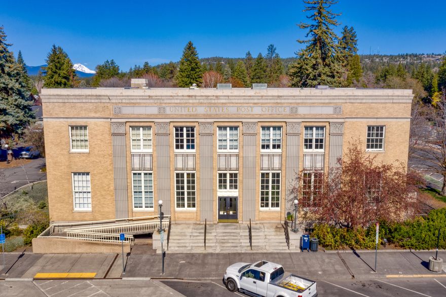 This is an incredibly rare opportunity to own a piece of Downtown Bend history. The Post Office Plaza is located inside the Commercial Business District (CB zone) which allows for a multitude of office, retail, residential and other commercial uses. Most of the suites are leased on a short-term basis with under-market rents creating an opportunity for future upside potential with a new owner. Additionally, a 36-space on-site parking lot could be developed into further building square footage, as Downtown Bend parking regulations are such that the on-site spaces are no longer needed (contact brokers for full offering memorandum).
The building was once home to the U.S. Post Office and has been transformed and upgraded over the decades since it was constructed in 1932. The three story building originally consisted of a 4,000 square foot foundation with one of the levels below grade. An addition was constructed in the 1980s. It currently has 19,352 square feet of gross building area (GBA).