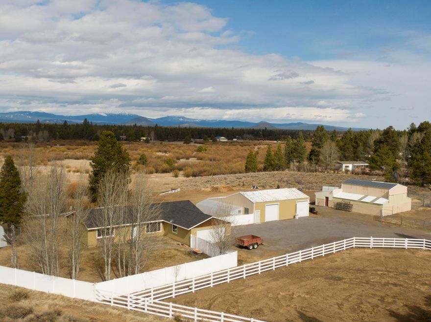 10.36 acres of picturesque horse property w/ views of the river & Cascades as the backdrop. Updated farmhouse w/ a gourmet kitchen & large windows in the main living area is perfect for entertaining. Kitchen ftrs dining area w/ large central island, granite counters, double oven, gas range w/ pot filler, full height designer backsplash & soap stone farm sink. Main living area is newly carpeted & right off kitchen w/ built-in entertainment area. Primary bedroom ftrs a tiled walk in shower, walk in closet. Two guest bedrooms share an updated walk-in tiled shower as well. Oversize laundry area w/ built ins & a sink, bonus room & half bath off entry. Property boasts a 5 stall barn, black sand arena, insulated tack room, & hay loft. Two in ground greenhouses w/ power & water for an extended growing season. A large shop, 400 amp power. Fish, kayak, swim or float in the Little Deschutes River in the summer. Horse trails nearby & close to skiing/snowmobile parks. High speed internet & no CCRs.