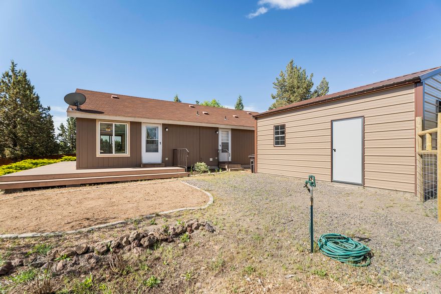 Check out this value!! This meticulously maintained 2 bedroom, 2 bathroom home is everything you could have hoped for. Cozy, yet spacious at 1,144sqft, it is light and bright with huge windows throughout, vaulted ceilings, and slider in the primary and kitchen. Kitchen has tons of storage, island with breakfast bar, and is open to the living space. Primary suite is a generous size with a walk-in closet, step-in shower, and private entrance onto the composite deck which wraps around the home. Outside you'll find a lovely back yard with manageable landscaping which includes mature trees, young fruit trees, greenery, and a lawn - all easily maintained with sprinklers in front and rear! Property is fenced, with interior deer-proof fencing around the house. Less than one year old, oversized single-car metal garage sits on a concrete pad and has power. Property also features heat pump, 30amp RV hook-up, paver patio in the rear, several water hydrants, and serenity!