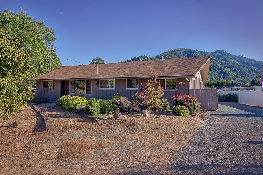 This home is truly special and unique. Experience the best of both worlds: a rural lifestyle without a commute in this large lovingly landscaped 3/4 of an acre lot in the heart of Rogue River. The home is tastefully updated and remodelled with tons of space, huge windows with natural light pouring into every room and 4 large bedrooms. A huge garage and naturally cooled cellar storage room detached by a comfortable breezeway. Large gardens and lovingly cared for bushes surround this home creating a peaceful and productive parklike place to relax and enjoy this sanctuary in town. Adding to the value of this home is the potential to split the lot into 4 to 5 more lots, making this land extremely valuable for immediate development or a long term investment that will certainly rise greatly in value as buildable lots become few and far between.