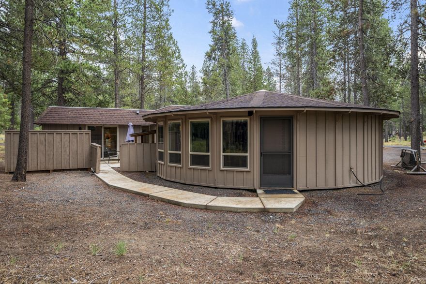 Peaceful and full of charm, this single-level Sunriver home offers 3 bedrooms and 2.5 bathrooms on a spacious lot surrounded by mature ponderosa pines. Just a short stroll from the shops, restaurants, and activities at Sunriver Village, the property has been thoughtfully updated throughout. The distinctive ''round house'' design features a wall of windows encircling the generous dining and kitchen areas, framing serene forest views. Inside, you'll find a large living room, a spacious primary suite, a junior primary with an ensuite powder room, and a classic bunk room. An enclosed concrete patio provides versatile space to entertain indoors, dine under the stars, or relax in your private hot tub. Offered turnkey and fully furnished, 1 Fawn is ready to enjoy—whether as a successful short-term vacation rental or your own private getaway.