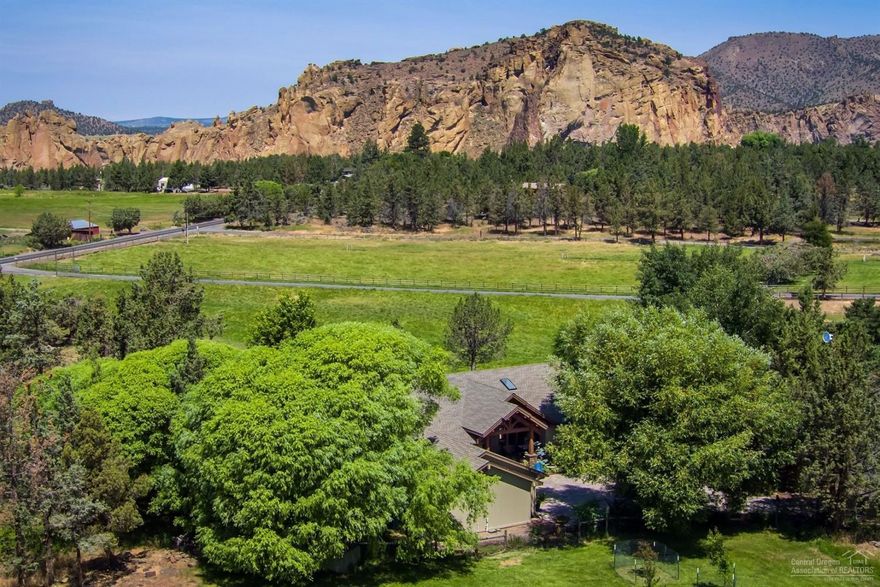Vistas of Smith Rock and the Cascade Mountains. 2,931 sf, 3 BDR, 2.5 BA home, barn, 9.3 acres of irrigated pasture, art/hobby studio, and two additional finished guest studios. Main home includes custom cabinetry, hardwood floors, remodeled/upgraded kitchen and powder rooms, views of mountains throughout. Extensive landscaping, patio, water feature. Property includes pond, irrigation, fencing and orchard. Take a walk or ride to nearby Smith Rock State Park from your backyard. Rare opportunity to savor a rural lifestyle and live in luxury and comfort, yet close to Redmond airport and Bend/Redmond social events/dining. This home and setting are hard to find with privacy and plenty of room for visitors.