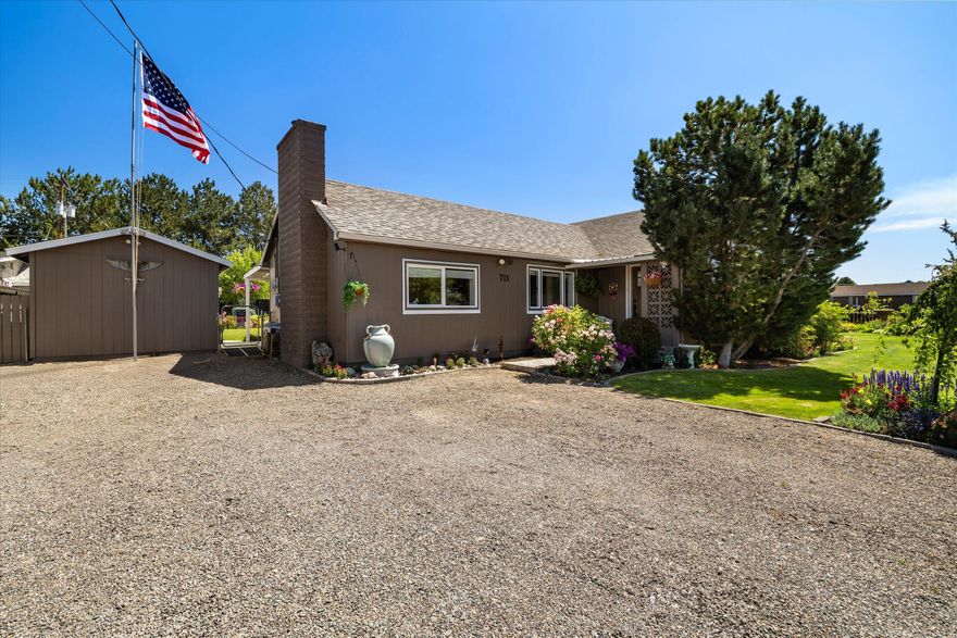 Park like paradise on .32 of an acre. This 3 bed 3 bath beautifully maintained single level home offers 2 primary suites, a bright living room w/recessed lighting, family room, nicely laid out country kitchen w/instant hot water, tasteful tile back splash, eating bar & large pantry area. The house has a lot of updating, including light fixtures. A lot of the plumbing has been updated & the house has a newer water main line & water meter. The lrg garage/workshop offers a great work area with a vise, air compressor, heat & a separate power meter. The backyard is loaded w/perennials & color galore. There is a large playground area so you have your own park. The large covered back patio overlooks the playground & one of the flower gardens. There are outbuildings for storage. The backyard is fenced & offers lots of parking and RV hookup & privacy. There is a hot water spigot outside the house for pools, dog baths, or? This special property is a must see.