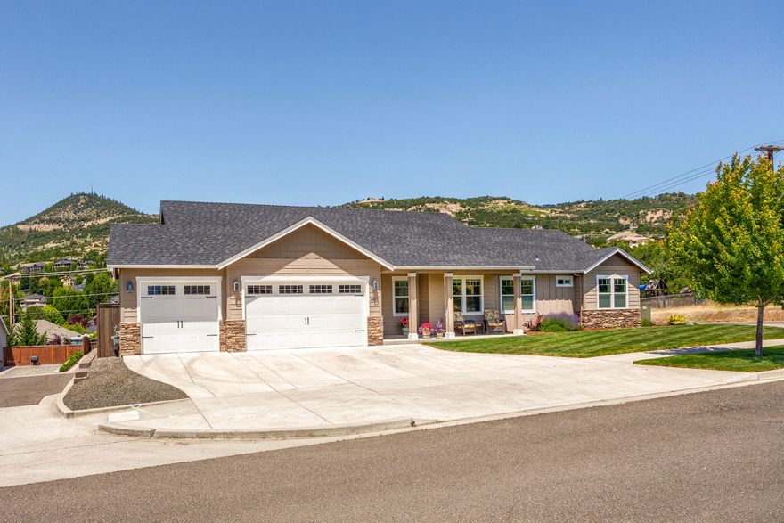 East Medford living at its finest! 4 bedroom 3 bathrooms, built in 2017 with 2,286 sq ft., 4th bedroom can be used for an office. The home is on a .20-acre corner lot.  Scenic views of Roxy Ann and surrounding mountains. The open floor plan has vaulted ceilings, offers a spacious kitchen with granite-counters, large island and ample cabinet space, nice walk-in pantry stainless appliances.  The home has elegant Laminate wood flooring, tile in all the bathrooms, and carpet in the bedrooms.  The gas fireplace insert in the Great Room is perfect for relaxing or entertaining.  Expansive windows flood the home with natural light, creating a warm, tranquil atmosphere. Master bedroom has a large walk-in closet and granite counters and double sinks. Tile is present in master shower and main bathroom shower/tub and both with double sinks. The home has a finished 3 car garage and laundry room with granite counter, sink and cabinets. Small back yard, covered deck, sprinkler & drip system