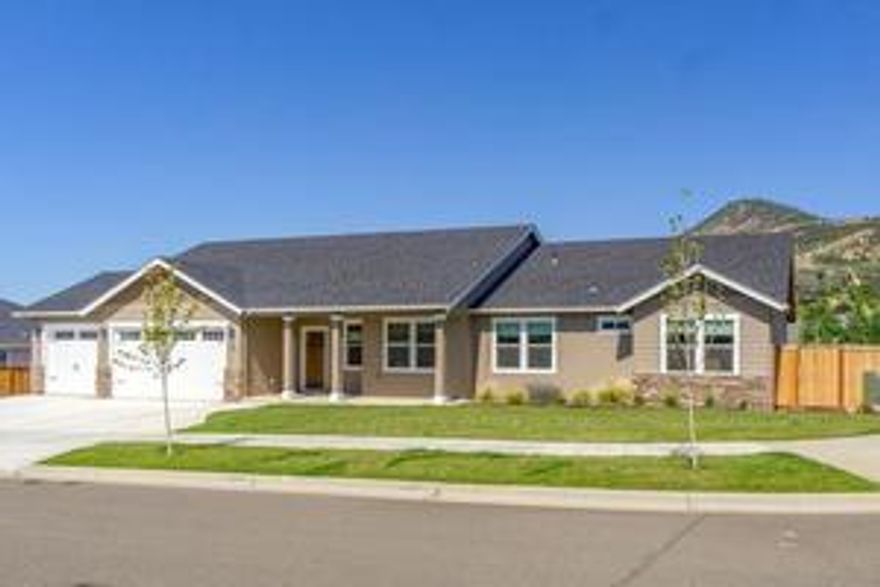 East Medford living at its finest! 4 bedroom 3 bathrooms, built in 2017 with 2,286 sq ft., 4th bedroom can be used for an office. The home is on a .20-acre corner lot.  Scenic views of Roxy Ann and surrounding mountains. The open floor plan has vaulted ceilings, offers a spacious kitchen with granite-counters, large island and ample cabinet space, nice walk-in pantry stainless appliances.  The home has elegant Laminate wood flooring, tile in all the bathrooms, and carpet in the bedrooms.  The gas fireplace insert in the Great Room is perfect for relaxing or entertaining.  Expansive windows flood the home with natural light, creating a warm, tranquil atmosphere. Master bedroom has a large walk-in closet and granite counters and double sinks. Tile is present in master shower and main bathroom shower/tub and both with double sinks. The home has a finished 3 car garage and laundry room with granite counter, sink and cabinets. Small back yard, covered deck, sprinkler & drip system