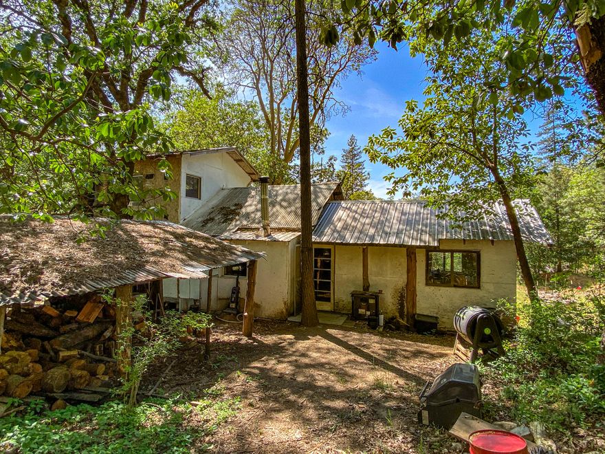 Rustic Cabin ready for your touch! Sitting on over 10 acres is this wonderful cabin ready for completion. Featuring a 1 bedroom loft, 1 full bath, nice kitchen and living area, plus large wood-burning fireplace. The woodwork throughout along with Tile bathroom and shower is quite custom.  Lots of mature timber across the creek which flows through the property. Great Well, septic, a few outbuildings and lots of sun for all your growing needs. Priced right allowing you to live in the cabin and build your dream home! Buyer to complete their own due diligence on use of property and legality of home.
