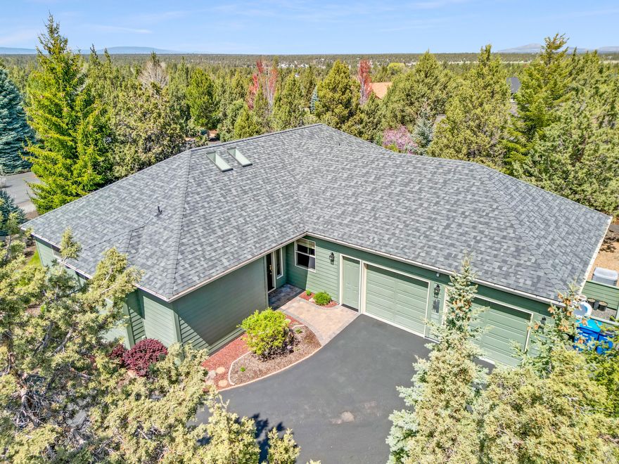 This spacious Eagle Crest home is thoughtfully designed with two en-suite bedrooms, a third bedroom/office, and a third full bathroom with jetted tub. Abundant windows allow the open floor plan to glow with natural light and draw in the quiet enclosure of mature trees and native plants surrounding the home. Designer touches include solid hickory flooring, quartz counters, and a capacious kitchen with peninsula seating and cook's workspace. Practical features include a wealth of storage, newer HVAC with allergy filtration, a generous laundry/craft room with 2 sinks, and an oversized garage with built-in cabinets and workbench. Outside you'll find Trex decking, paver patio, retractable shade awning, raised garden beds, low maintenance natural landscaping with gravel paths, and lots of privacy and tranquility. Enjoy EC golf courses; indoor and outdoor pools, pickleball, and tennis; sports centers and spa; and miles of trails.