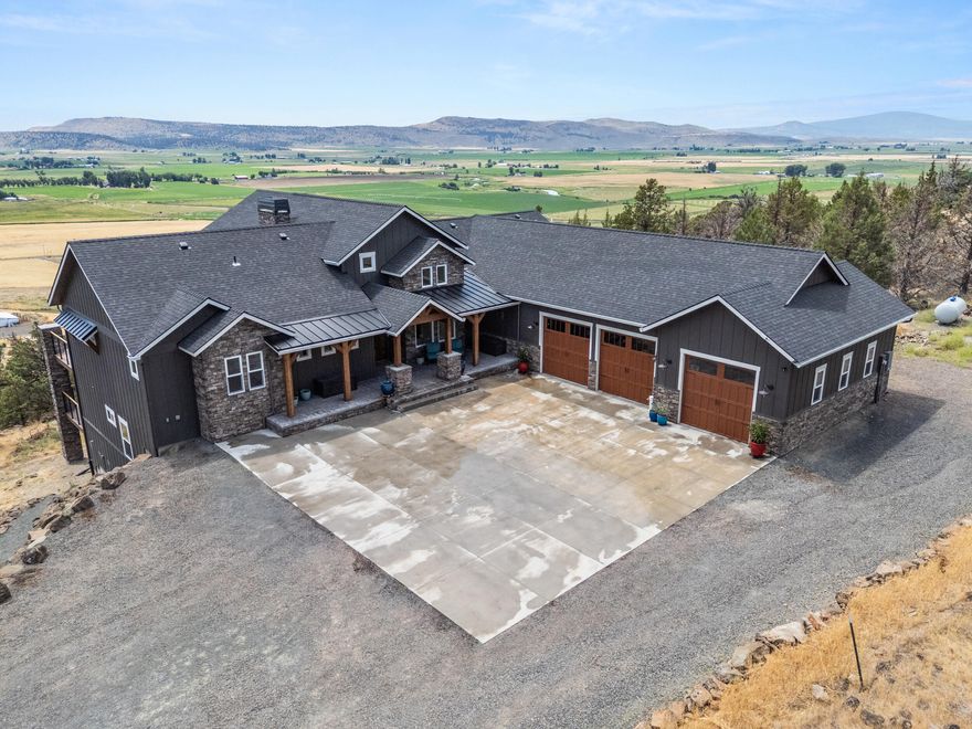 Absolutely incredible custom built home, recently finished in 2024! There were no details spared when it came to the building of this home. Breathtaking views, 3 decks, an outdoor fireplace, and top of the line finishes throughout this beautiful home. Propane generator along with on demand water heaters. Triple filtered well. The entry is grandiose w/ the living room, open to the kitchen and nook, accentuated by the vaulted ceilings, large sliding doors,  windows almost floor to ceiling, & exposed beam finishes. The kitchen is a chef's dream, with a Bertazzoni Range, 2 additional ovens, Full size fridge and freezer. Bedrooms have en suite bathrooms, with a half bath on the main level. Including 2 living rooms, one up, one down, and an additional theater room downstairs. The gym downstairs has its own entrance creating the possibility for an adu. In the 4th bay of the climate controlled garage, state of the art collapsible golf simulator that will stay with the home! This..is..the..one