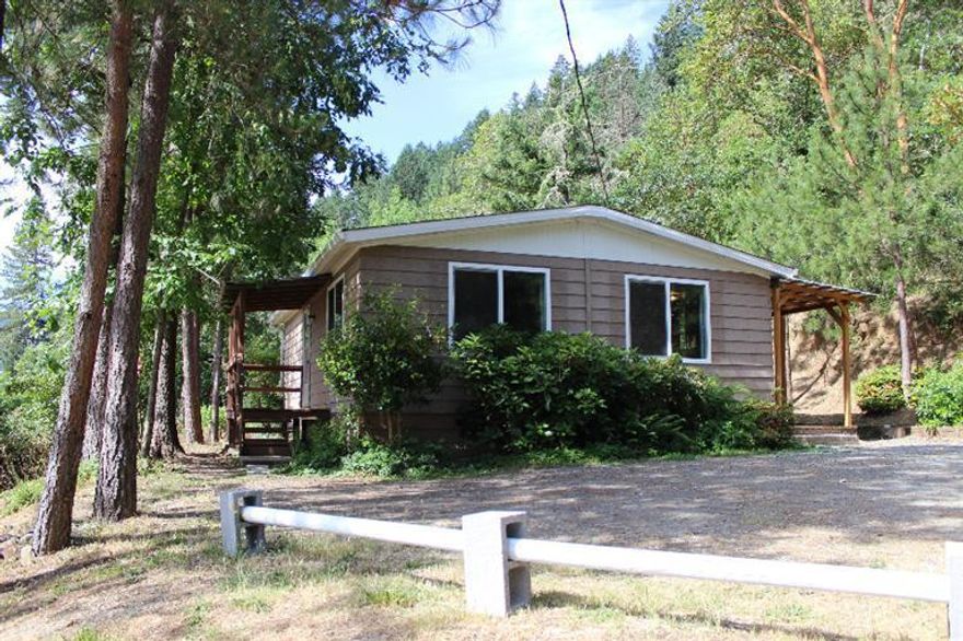 Clean 2 Bedroom manufactured home on over 3 acres. Set across the street from the beautiful Applegate River on a semi secluded treed lot. The property features raised garden beds, RV parking, a gardening/storage shed & terrific mountain views. The home has some updated windows, central heating, partially updated flooring & an open floor plan. Covered front & back patios are great for enjoying the mountain air. The owner may carry to a qualified buyer with adequate down payment. This home would make a great rental and would show a good return to a potential new owner. Details on potential rent and income available upon request.