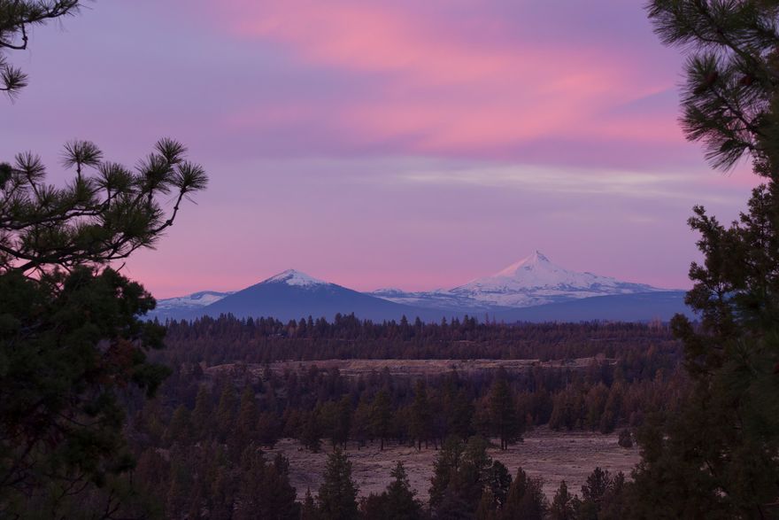 Breathtaking, unobstructed mountain & river views unfold across this elegant, expansive home.  Situated above the Deschutes River canyon in NW Bend, the property is conveniently located minutes from dining & shopping options and affords quick access to the Deschutes River Trail. Panoramic vistas encompass rim rock, forests and meadows of Riley Ranch Nature Reserve and Cascade Mountain peaks including Mt Washington, Mt Jefferson, & Mt Hood. Enjoy the sights & sounds of the Deschutes River descending through boulders and rapids which seasonally challenge kayakers. The architecturally impressive exterior features Camas basalt and extensive decking. The thoughtfully designed interior incorporates a private primary suite, guest rooms in a separate wing plus 2 offices. A huge, flexible bonus room includes built-in desks, Murphy bed & wet bar. The salt-water indoor pool allows year round exercise, and the primary bath features radiant heat, steam shower and soaking air tub. Incomparable!
