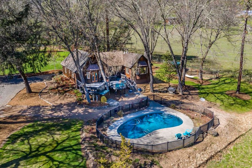 Walk down your driveway to catch a salmon in the Rogue River! Or put in your kayak & glide through Class lll-V rapids! All that & more, from this enchanting 9.39-acre property featuring a Northwest style 3-bed, 2 bath home. Set well back from the road, bordering BLM land, the property is private, & beautifully treed w/a touch pad security gate. Charming home w/a large, modernized island kitchen that includes upgraded appliances, hardwood floors & a walk-in pantry. Dining area, living room w/woodstove, & a newly updated guest bath. Spacious master w/double closets, French doors leading to the deck, & updated master bath. Expansive deck, gated inground pool, amazing garden area w/deer fencing & raised beds, chicken coop & extra pen. Ideal horse property set-up w/a round pen & a 40x25 foot 2 stall barn w/one padded stall. Two tax lots for a possible 2 family set-up, water rights & conveniently located close to golf courses & wineries, only 20 minutes to RV International Airport.