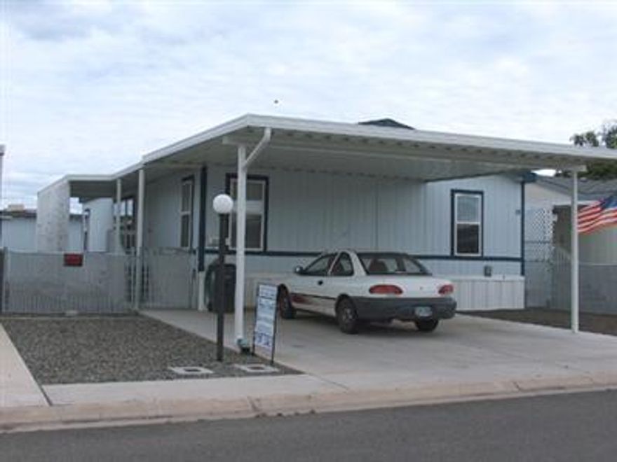 Newer Adult Park. Nice wide street and newer homes. Home has vaulted ceiling with a great open living room-kitchen combination. Eating and work center in kitchen plus a dining area. Large utility room. Split floor plan for bedrooms. Large wooden storage building. Home is well maintained and shows like new. Carport is side by side with room for two cars. Yard has chain link fencing.