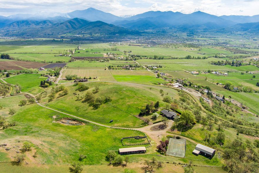 Knoll top setting with 360 degree valley vistas.  One of the prime locations in the Rogue Valley. This classic  ranch style home has been updated with a beautiful kitchen / great room addition. Large deck overlooking the greater Rogue Valley. End of the road privacy. Large barn with full loft. Older tennis court. Almost 20 acres of irrigation. Newer roof. Good well as per the seller. This is a prime spot for a vineyard with excellent air circulation. This is a must see for any buyer seeking complete privacy, irrigation rights and the top of the world feel. Perfect for horses also.